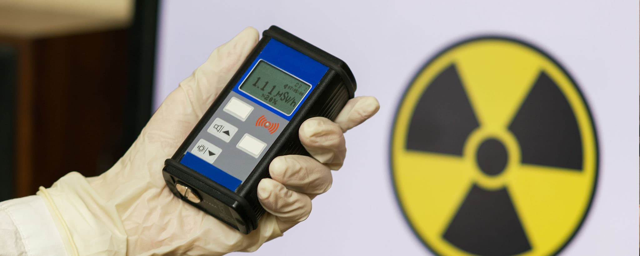 Person holding a Geiger counter during a radiation emergency — FEMA Ready.gov nuclear preparedness hero image